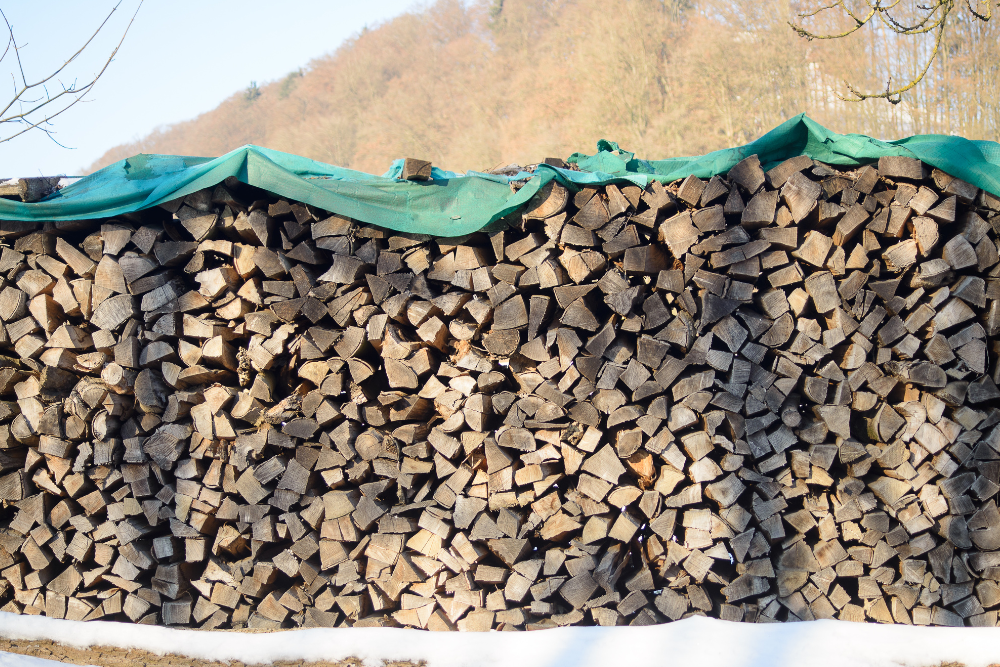 Stockage de bois de chauffage sous bâche verte